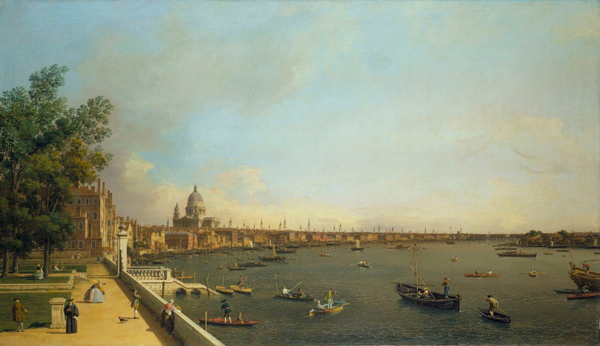 A classical landscape painting depicting a view of a city across a large body of water. The scene features numerous boats and ships on the water, with a grand domed building, possibly a cathedral, in the centre of the cityscape. The sky is filled with wispy clouds, and trees line the embankment in the foreground.