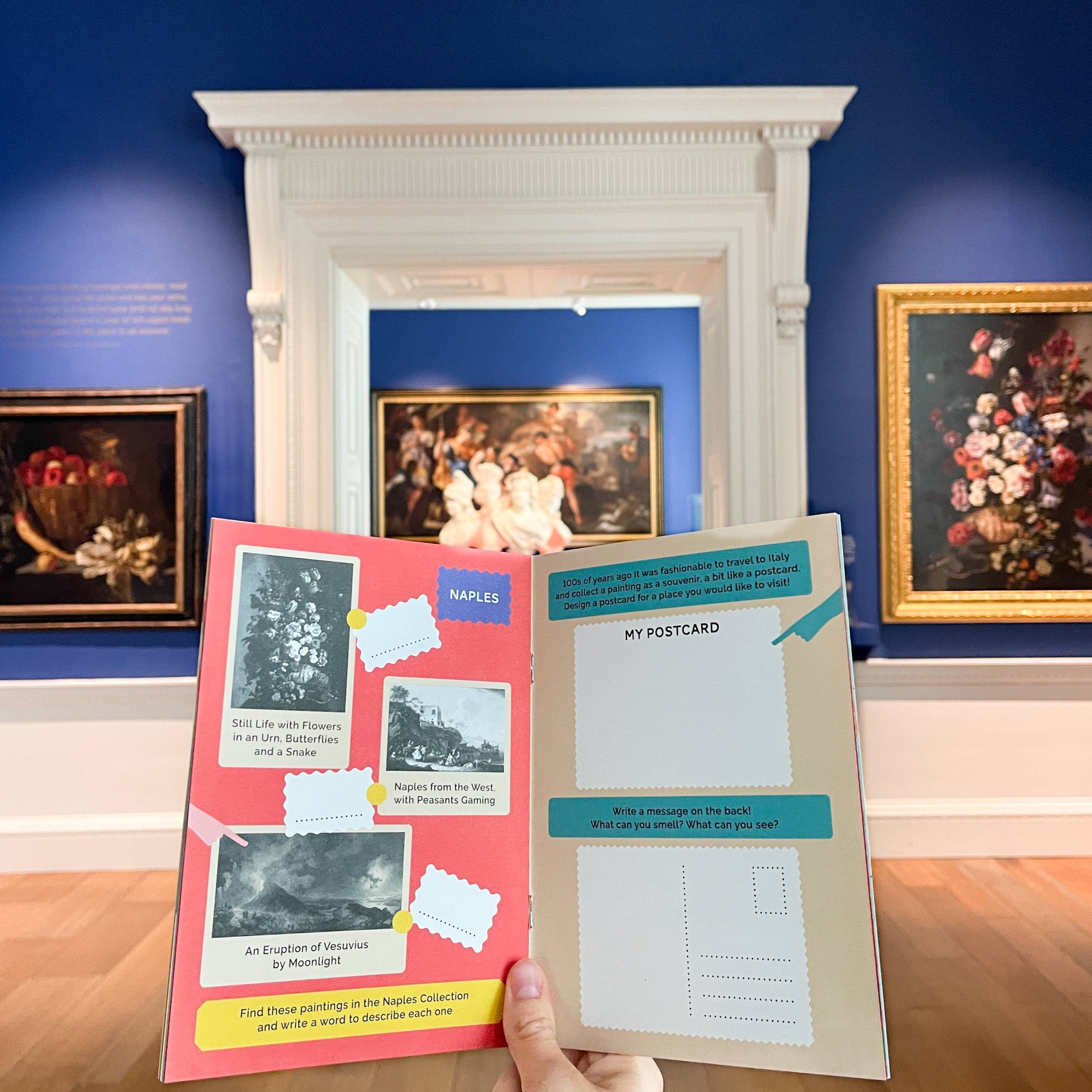 A hand is pictured holding a blue book titled 